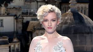 Julia Garner, Amerikalı bir oyuncu olarak son yıllarda Hollywood’un en dikkat çeken yeteneklerinden biri haline gelmiştir. 1 Şubat 1994 tarihinde The Bronx, New York’ta doğan Garner, özellikle güçlü dramatik performansları ve sıra dışı karakter seçimleriyle tanınmaktadır.