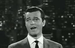 Robert Goulet, 20. yüzyılın ortalarından itibaren özellikle Broadway sahnelerinde ve konser dünyasında tanınmış, güçlü bariton sesi ve sahne karizmasıyla dikkat çeken bir Kanadalı-Amerikalı şarkıcı ve oyuncudur. Müzikal tiyatronun altın çağında yükselen Goulet, hem sahne performansları hem de televizyon ve sinema projeleriyle geniş bir hayran kitlesine ulaşmıştır.