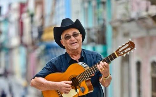 Küba müziğinin dünyaya tanıtılmasında büyük rol oynayan sanatçılardan biri olan Eliades Ochoa Bustamante, gitaristliği, güçlü vokali ve geleneksel Küba müziğine bağlılığıyla öne çıkan önemli bir müzisyendir. Küba'nın doğusunda, Santiago de Cuba yakınlarında bulunan Loma de la Avispa, Songo La Maya bölgesinde 22 Haziran 1946'da dünyaya gelen sanatçı, çocukluk yıllarından itibaren gitarla tanışmış ve yaşamını büyük ölçüde müziğe adamıştır.