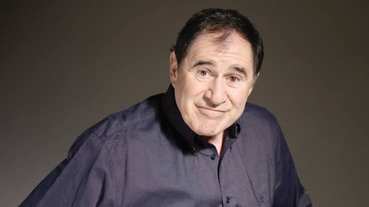 Amerikan sinemasının ve televizyon dünyasının deneyimli karakter oyuncularından biri olan Richard Kind, özellikle komedi türündeki başarılı performanslarıyla tanınsa da kariyerini yalnızca mizahi rollerle sınırlamayan çok yönlü bir sanatçıdır. Sinema filmlerinden televizyon dizilerine, Broadway sahnelerinden animasyon yapımlarına kadar uzanan geniş bir çalışma geçmişine sahip olan Kind, farklı karakterleri kendine özgü oyunculuk anlayışıyla yorumlamayı başarmıştır.