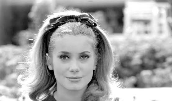 Fransız sinemasının uluslararası alanda tanınan en önemli temsilcilerinden Catherine Deneuve, uzun yıllara yayılan oyunculuk kariyeri, karakter seçimlerindeki çeşitlilik ve kendine özgü ekran duruşuyla sinema tarihinde özel bir yere sahiptir. Gençlik döneminde zarafeti ve etkileyici görünümüyle dikkat çeken sanatçı, zamanla yalnızca bir sinema yıldızı olarak değil, farklı sinema akımlarını ve kuşakları bir araya getiren deneyimli bir oyuncu olarak da tanınmıştır.
